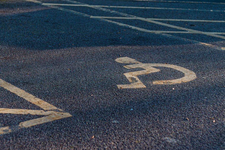 Close-up view of an asphalt parking space marked with a white number '22' and partially visible adjacent parking lines, located outside a property. The surface appears slightly textured and weathered,
