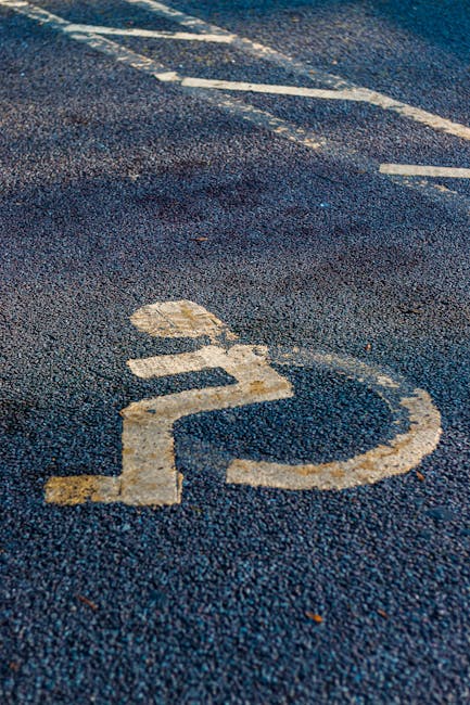 Close-up view of an asphalt parking space marked with a white number '22' and partially visible adjacent parking lines, located outside a property. The surface appears slightly textured and weathered,